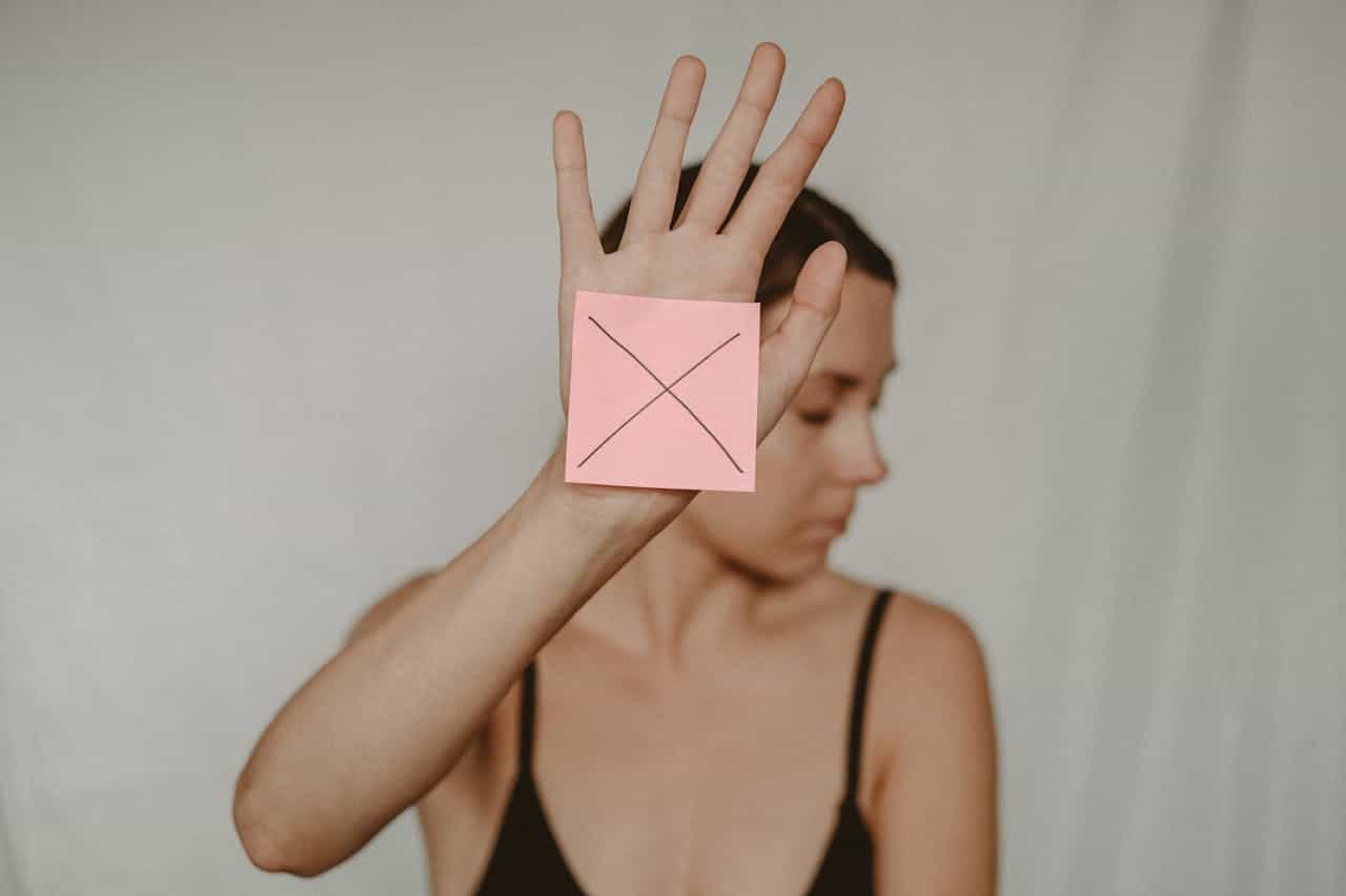 Photo by Anete Lusina: https://www.pexels.com/photo/woman-with-paper-with-cross-sign-5723269/