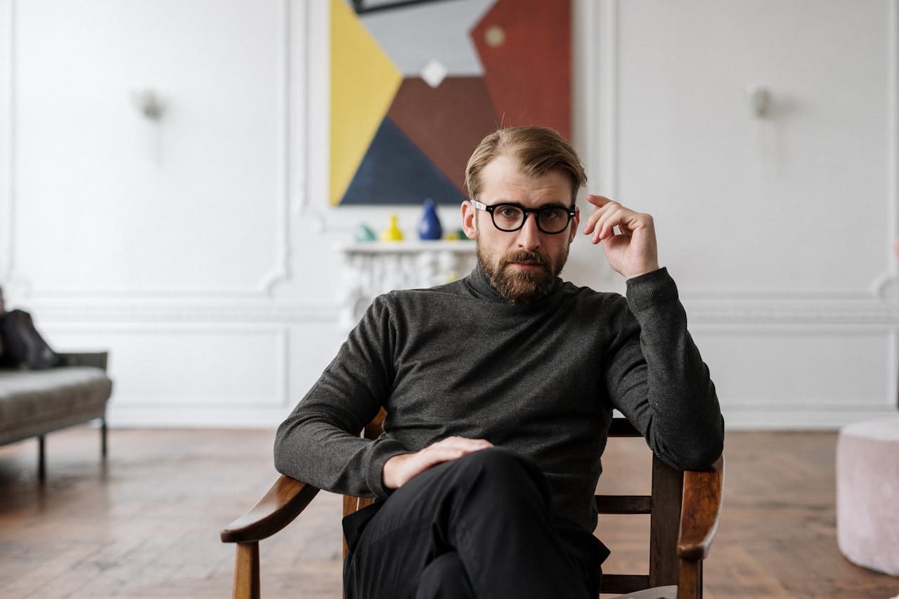 Photo by cottonbro studio: https://www.pexels.com/photo/man-in-black-sweater-sitting-on-brown-wooden-chair-4100672/