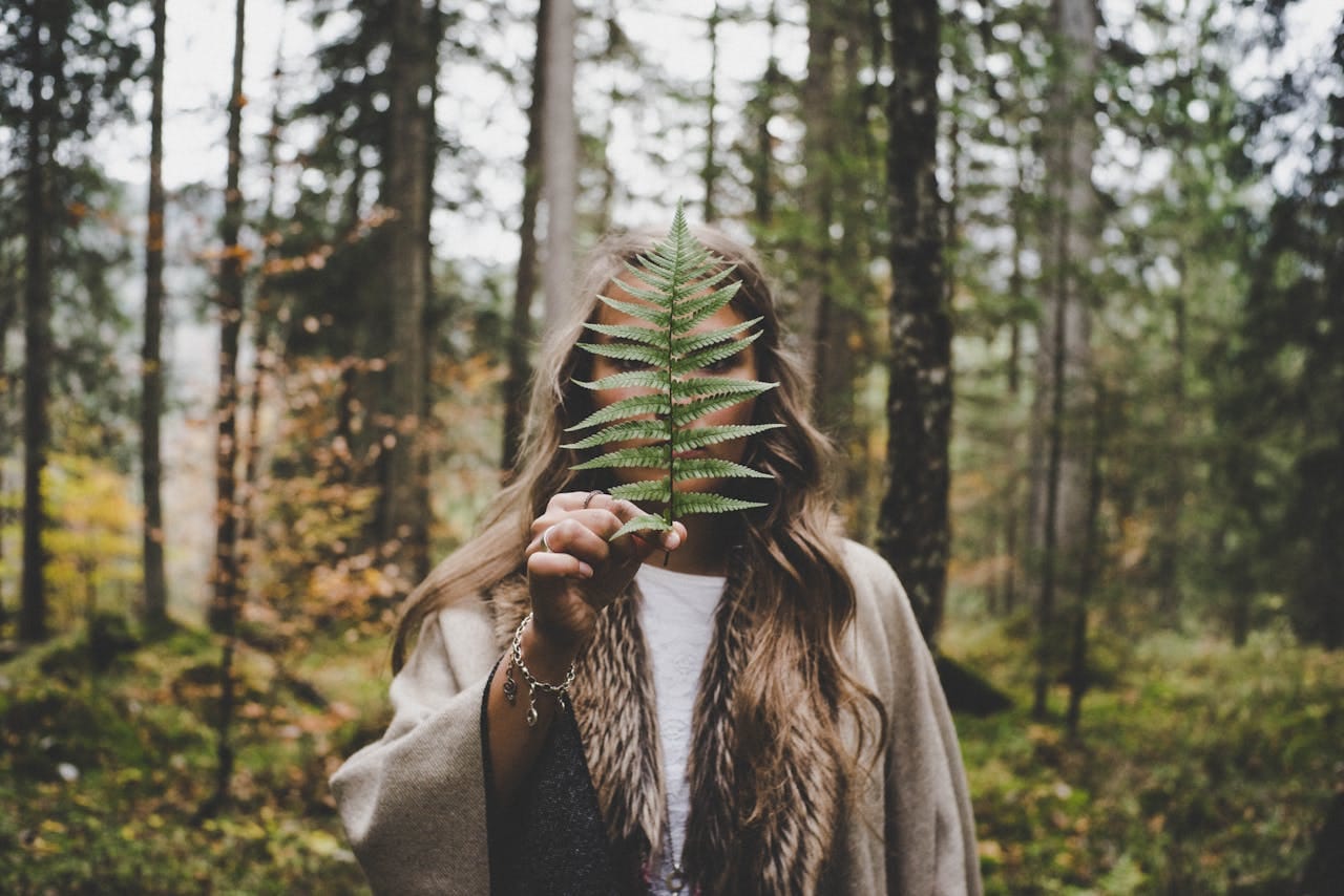 Photo by Lucas Allmann: https://www.pexels.com/photo/woman-standing-at-woods-holding-green-plant-612891/