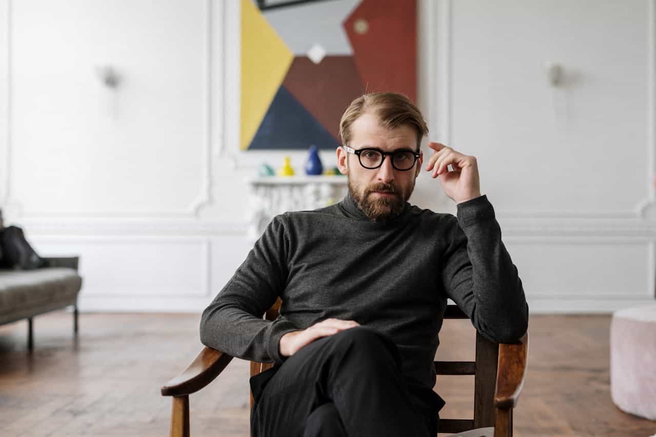Photo by cottonbro studio: https://www.pexels.com/photo/man-in-black-sweater-sitting-on-brown-wooden-chair-4100672/